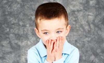 Young Boy Hiding Face In Hands